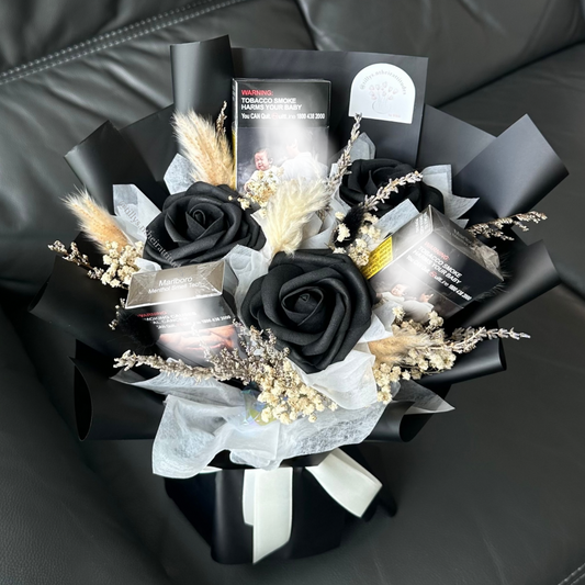 Bouquet of black roses and dried flowers and 3 boxes of cigarette packets inside of the flower bouquet, wrapped in black.