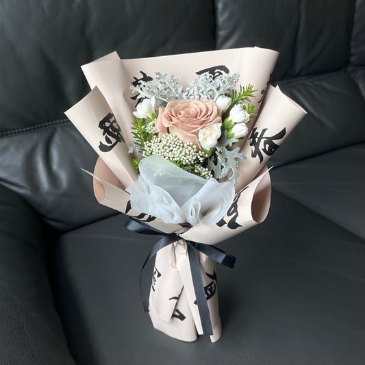 A bouquet of flowers, including a rose and white carnations, with green leaves, beautifully wrapped with a pattern inspired by classic Chinese poetry.