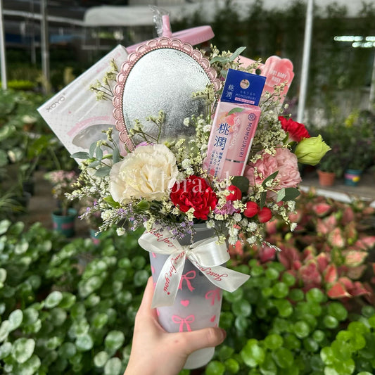 Bouquet of fresh flower in a re-usable cup. w, lipbalm. lashes, and lipstick included in the floral arrangement.