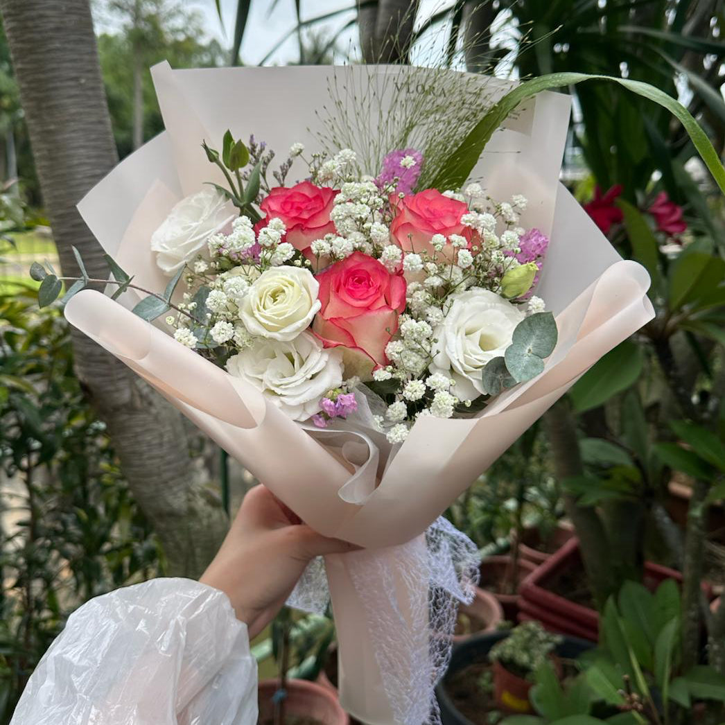 Bouquet of pink roses flowers held by a person with a natural background