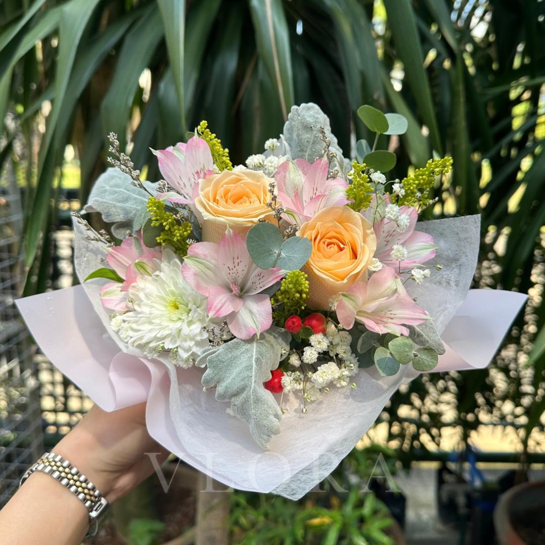 Bouquet of flowers held by a person with a blurred green background