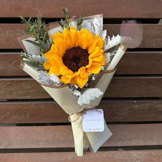 Bouquet of sunflowers with greenery on a wooden surface