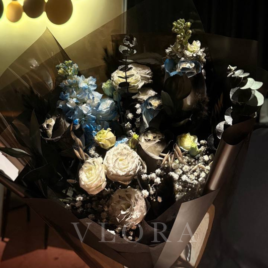 Bouquet of black flower bouquet with a tinge of blue and the bouquet is wrapped in black.